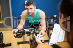 Trainer timing man on exercise bike