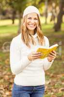 Portrait of a smiling pretty woman reading a book