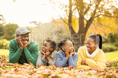 Portrait of a young smiling family lying in leaves