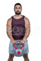 Muscular serious man holding a kettlebell