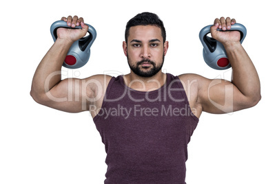 Muscular serious man lifting kettlebells