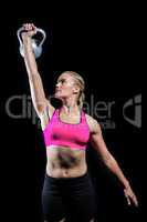 Muscular woman lifting heavy kettlebell