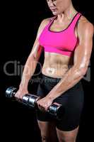 Muscular woman lifting heavy dumbbells