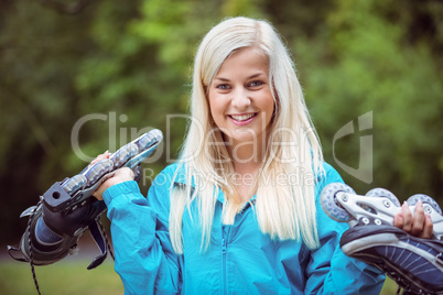 Happy blonde holding inline skates