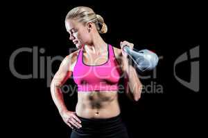 Muscular woman lifting heavy kettlebell