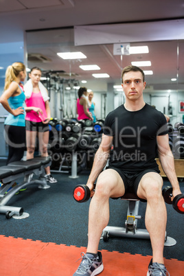 Fit man lifting heavy black dumbbells