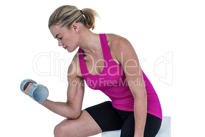 Muscular woman exercising with dumbbells