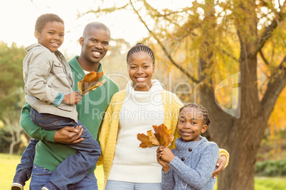 Portrait of a young smiling family holding leaves