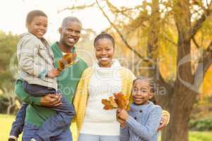 Portrait of a young smiling family holding leaves