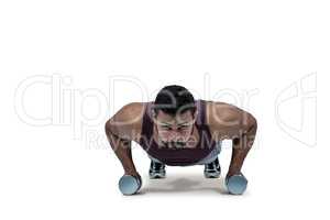 Muscular man doing push ups with dumbbells