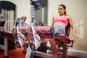 Focused woman using a weights machine