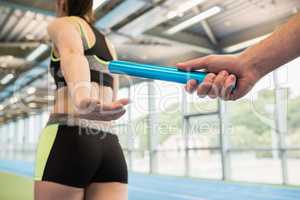 Man passing the baton to partner on track