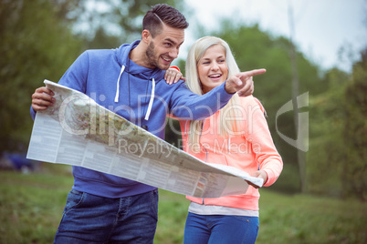 Happy couple reading a map together Happy couple reading a map together