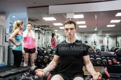 Fit man lifting heavy black dumbbells