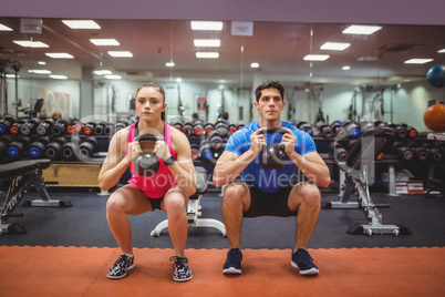 Fit couple working out in weights room