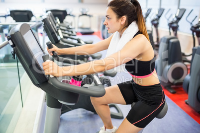 Focused woman using the exercise bike