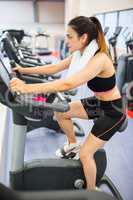 Focused woman using the exercise bike