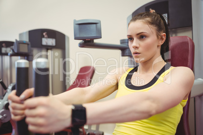 Fit woman using weights machine