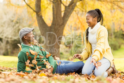 View of a young smiling couple in leaves