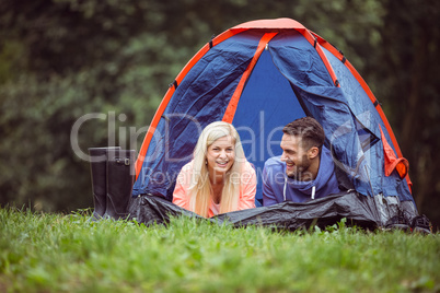 Happy couple lying in their tent