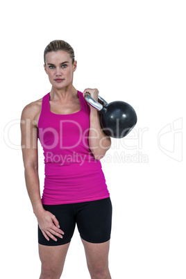 Muscular woman exercising with kettlebell