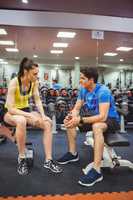 Fit couple chatting in weights room