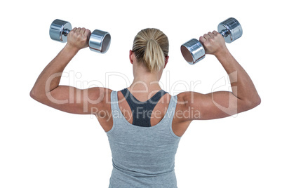 Muscular woman working out with dumbbells