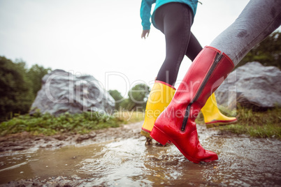 Women splashing in muddy puddles