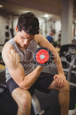 Fit man lifting heavy black dumbbell