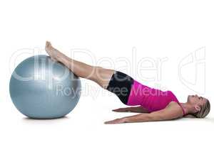 Side view of woman exercising with ball