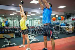 Man and woman working out using kettle bells