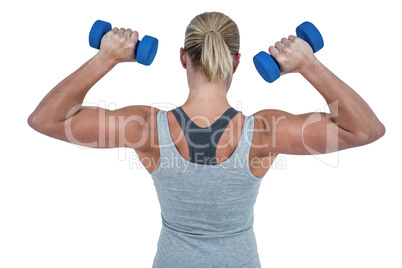 Muscular woman working out with dumbbells