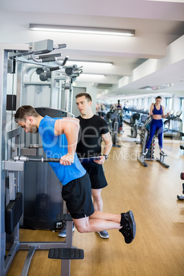 Fit man working out with trainer