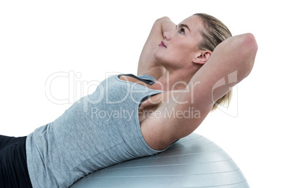 Muscular woman doing sit ups on exercise ball