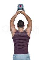 Muscular serious man lifting a kettlebell