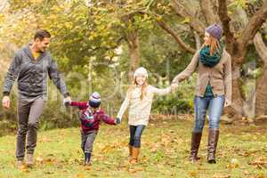 Smiling young family holding hands