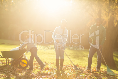 Young family picking up leaves