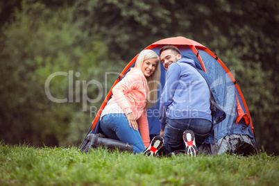 Happy couple setting up their tent