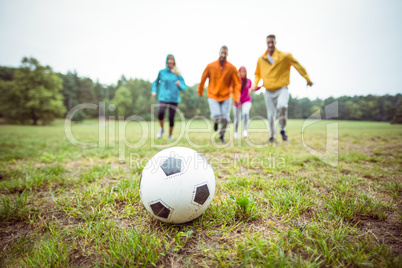 Friends running towards football