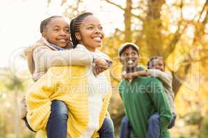 Portrait of a young smiling family in piggyback