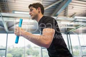 Fit man running on track with baton