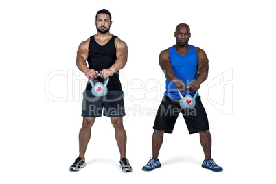 Strong friends lifting kettlebells together