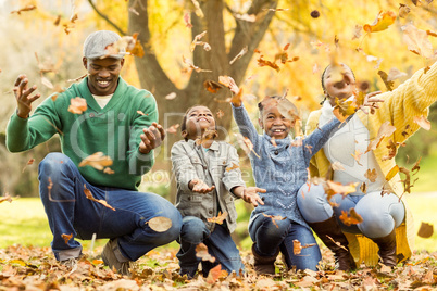 Young smiling family throwing leaves around