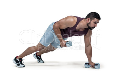 Muscular man doing push ups with dumbbells