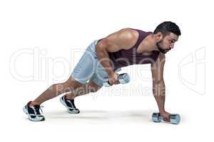 Muscular man doing push ups with dumbbells