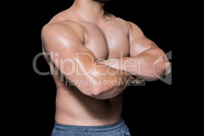 Mid section of a bodybuilder man with arms crossed