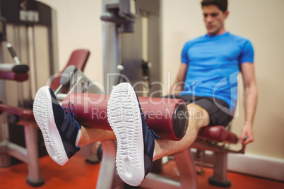 Fit man using weights machine for legs