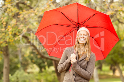 Smiling young woman under umbrella