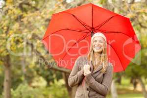 Smiling young woman under umbrella