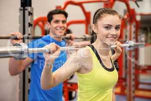 Man and woman lifting barbells together